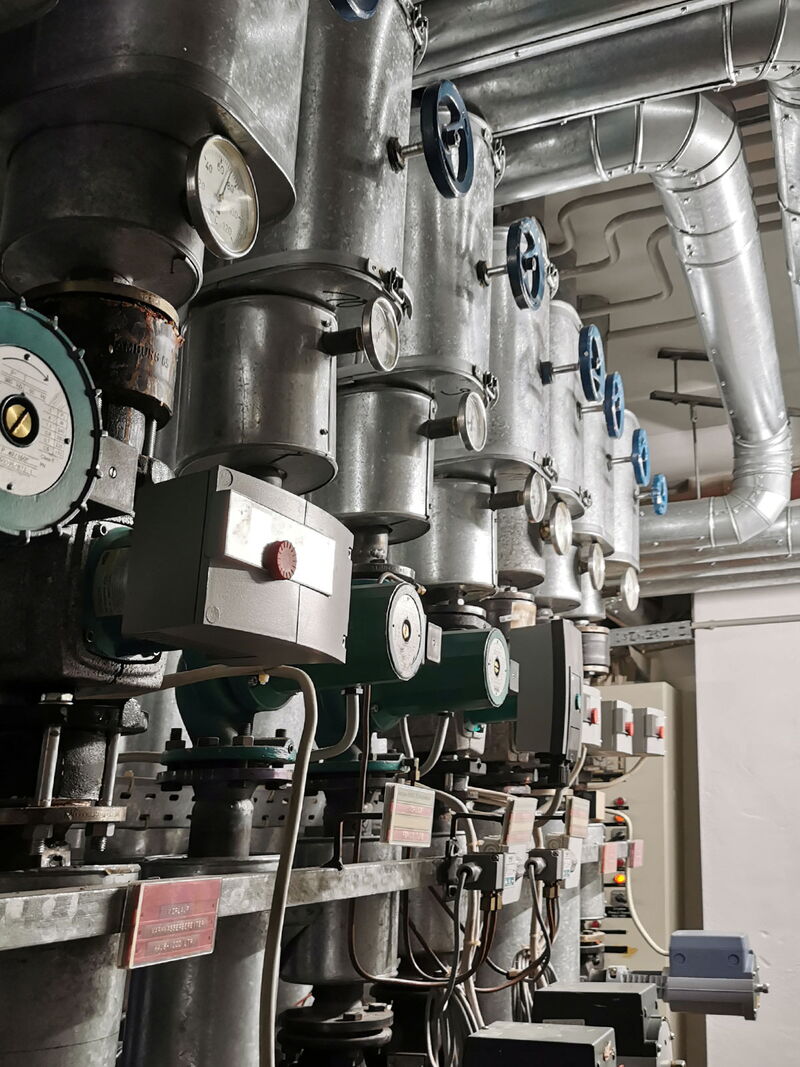 Innenansicht eines Technikraums mit komplexer Heiztechnik und Rohrsystemen
