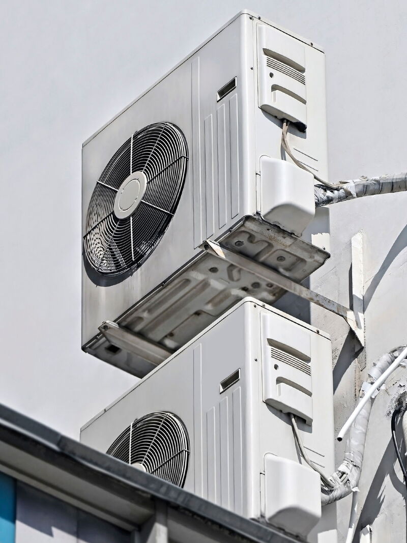 Moderne Klimaanlage mit Außen- und Inneneinheit an einer Gebäudefassade